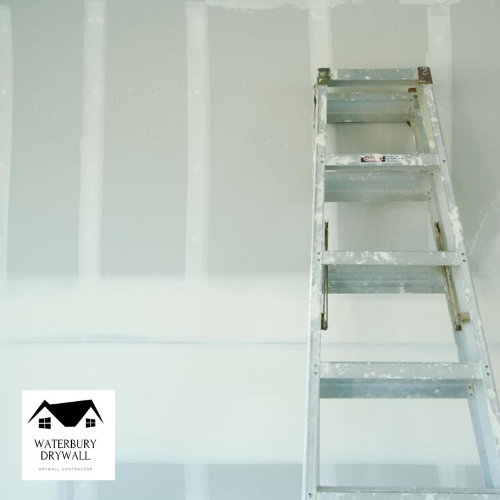 This picture is a ladder leaning against drywall that is being finished by waterbury drywall